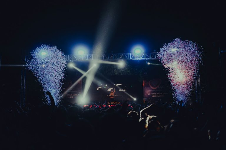a crowd of people at a concert with fireworks